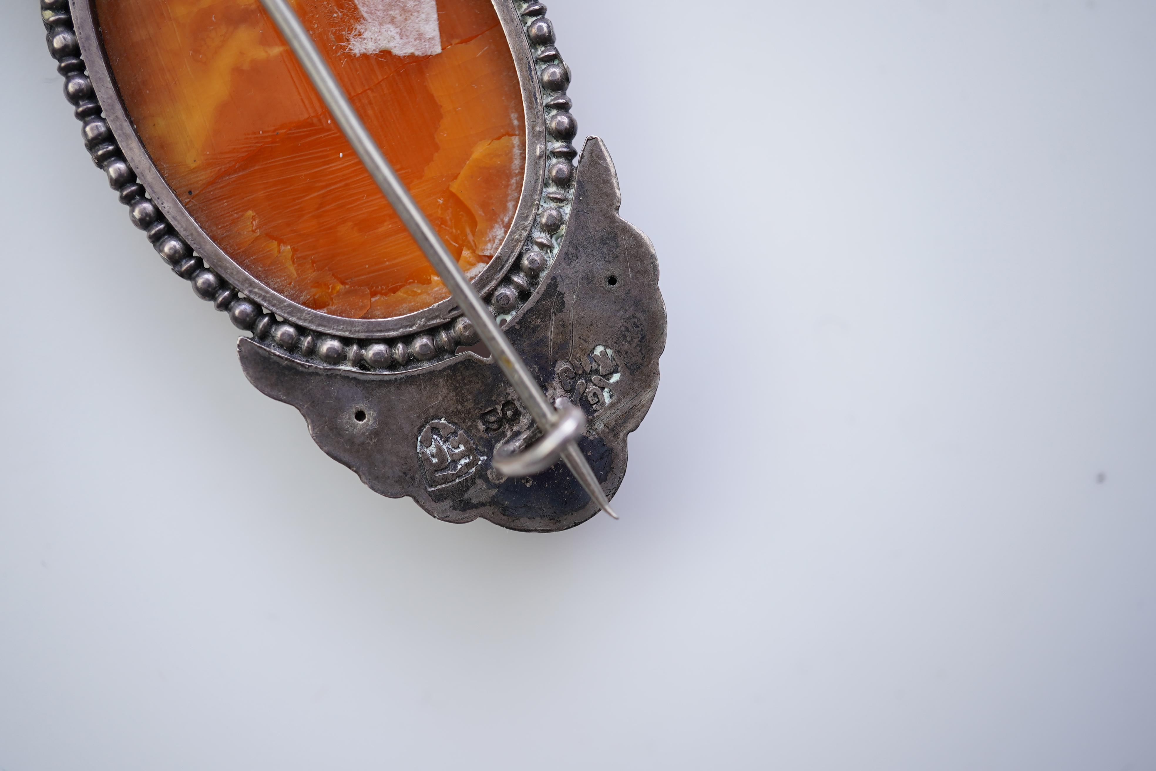 Three Arts & Crafts silver and amber brooches, early 20th century